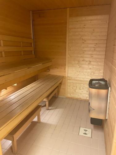 a sauna with a bench and a trash can at SamiCity Hotel As in Karasjok