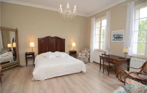 ein Schlafzimmer mit einem weißen Bett und einem Kronleuchter in der Unterkunft Beautiful Home In Arles With House A Panoramic View in Albaron