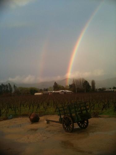 a rainbow in the sky over a field with a bench at Hotel Terraviña in Santa Cruz