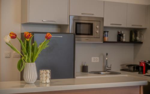 a kitchen with a vase of flowers on a counter at Amare Luxury Apartments in Budva