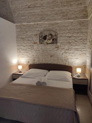 a bedroom with a bed with two night stands and two lamps at Dimore Vino&Amore in Alberobello