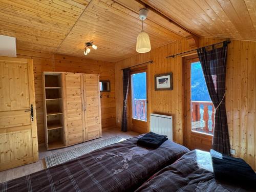 1 dormitorio con 1 cama en una habitación de madera en Charming, cosy chalet nestled in a breathtaking surrounding with spectacular, stunning mountain views, en La Chapelle-dʼAbondance
