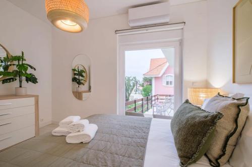 1 dormitorio con 1 cama con toallas en Portugal Portfolio - Seascape Apartment Unit 1, en Estoril