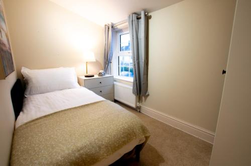 um pequeno quarto com uma cama e uma janela em Salisbury Residence by Charles Hope em Salisbury