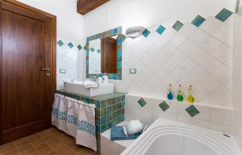 Un baño con bañera, lavabo y espejo. en Brassol Casa Vacanze Vista Mare, en Alghero
