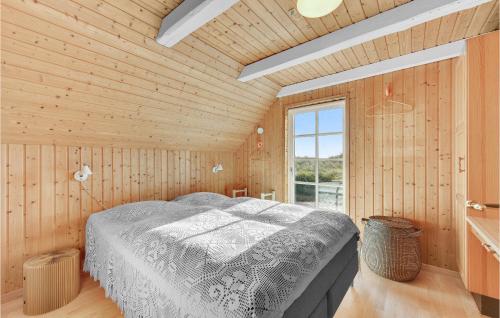 Nørre LyngvigにあるNice Home In Ringkbing With 3 Bedrooms, Sauna And Wifiの木製の部屋にベッド1台が備わるベッドルーム1室があります。
