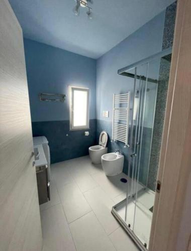 a blue bathroom with two toilets and a shower at Les Amis appartamento anzio in Anzio
