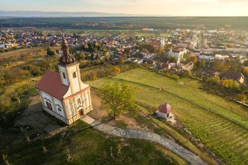 a small church on a hill with a town in the background at Hotel Beta in Bzenec