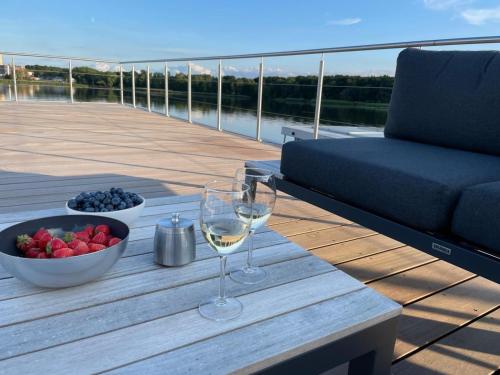 una mesa con dos copas de vino y un tazón de fruta en AURORA, en Lübeck
