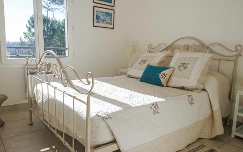 uma cama branca num quarto branco com uma janela em Villa LAube em Pierrevert