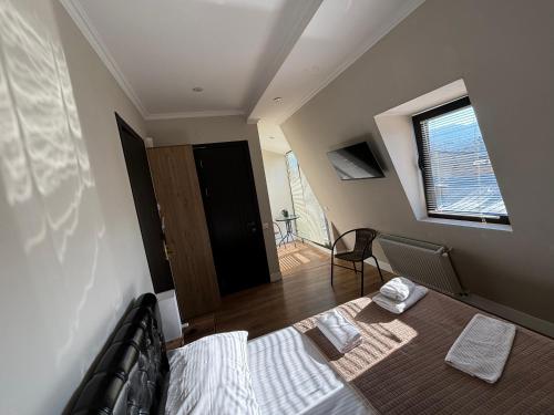 Zimmer mit einem Bett, einem Fenster und einer Tür in der Unterkunft D and D hotel in Tbilisi City