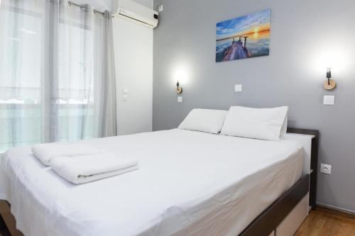 a bedroom with a large white bed with a window at Modern Cozy 1 Bd Piraeus Perfection Apt in Piraeus