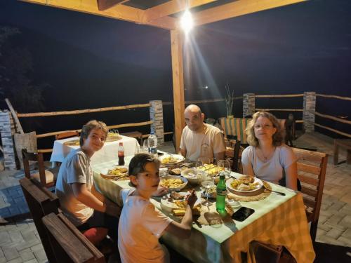 a group of people sitting at a table eating food at Kaza Ladera in Seladinha