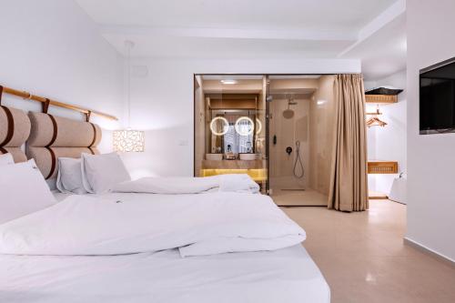 two beds in a white room with a television at Vila Bisera in Ohrid