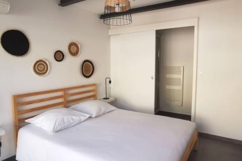 - une chambre avec un grand lit blanc et 2 réveils sur le mur dans l'établissement Le Lumineux l Clim l Parking l Terrasse l Paisible, à Istres