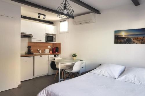 une chambre avec un lit et une table et une cuisine dans l'établissement Le Lumineux l Clim l Parking l Terrasse l Paisible, à Istres