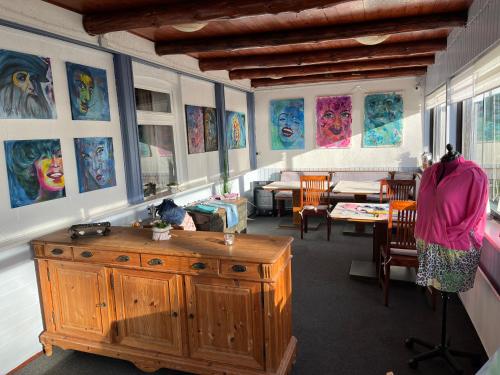 Zimmer mit Gemälden an den Wänden und einem Holzschrank in der Unterkunft Seefahrer Musik- & Kreativhotel in Osten