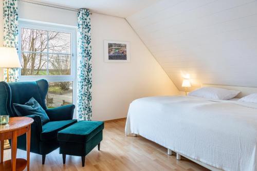 um quarto com uma cama, uma cadeira e uma janela em Ferienwohnung am Schlossberg em Odelzhausen