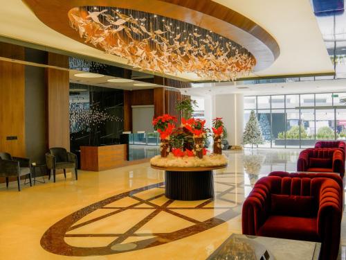 um lobby com uma mesa com flores em Ramada Hotel & Suites by Wyndham Erbil 32 Park em Arbil