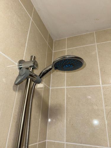 a shower with a shower head in a bathroom at Cardiff Grangetown Stylish 3Bed House. in Cardiff