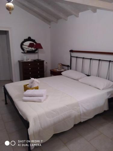 a bedroom with a large white bed with towels on it at Charouda stone tower xenonas in Pyrgos Dirou