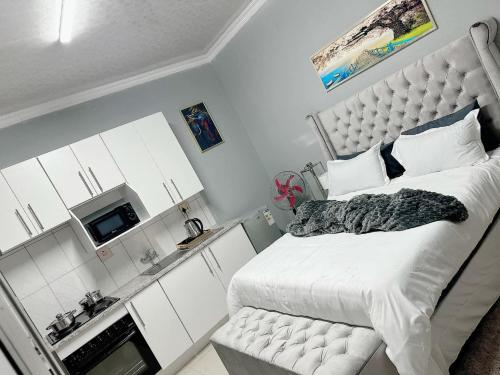 um quarto com uma cama grande e um micro-ondas em StayComfyApartment &Guesthouse By punky em Pretoria