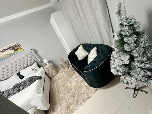um quarto com uma árvore de Natal ao lado de uma cama em StayComfyApartment &Guesthouse By punky em Pretoria