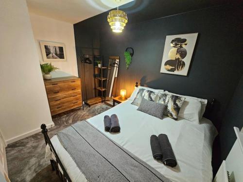 a bedroom with a large bed with slippers on it at Homebird Property - Waltz House in Sheffield