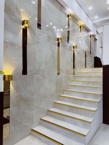 a lobby with a staircase with gold accents at Mildom Hotel in Almaty