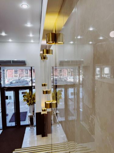 a lobby with a large glass wall and a staircase at Mildom Hotel in Almaty