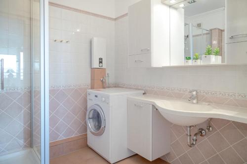 uma casa de banho com uma máquina de lavar roupa e um lavatório em Möwennest in der Strandstraße em Westerland