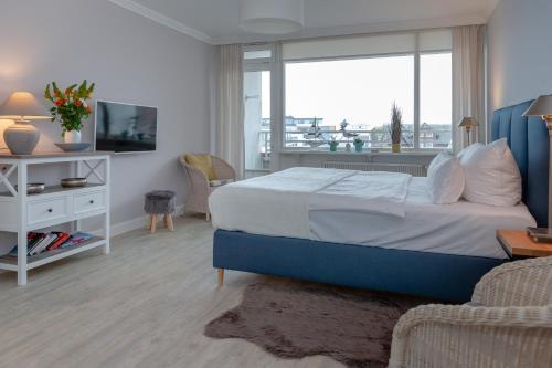 a bedroom with a bed and a large window at Möwennest in der Strandstraße in Westerland