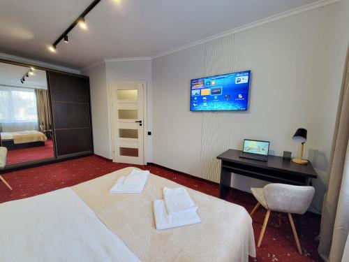 a bedroom with a bed and a desk and a television at Fine Ap4youIF in Ivano-Frankivsʼk