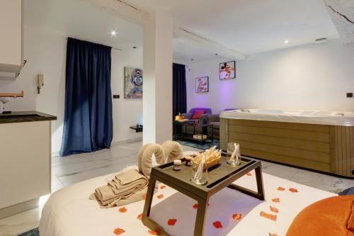 Cette grande chambre comprend un lit et une table. dans l'établissement Suite Romantique - Centre historique, Jacuzzi, wifi, 10min gare, à Montpellier