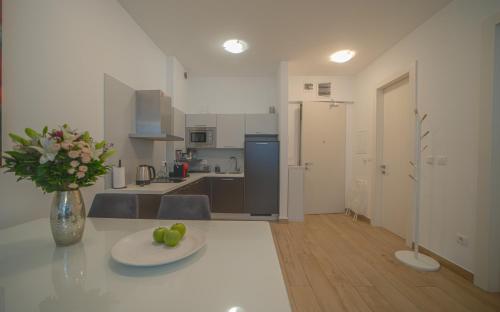 a kitchen with a table with a plate of fruit on it at Amare Luxury Apartments in Budva