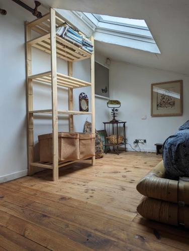 Cette chambre comprend une mezzanine et un canapé. dans l'établissement Loft cosy et lumineux à Paris,Les Lilas dans un quartier convivial proche du métro 11 