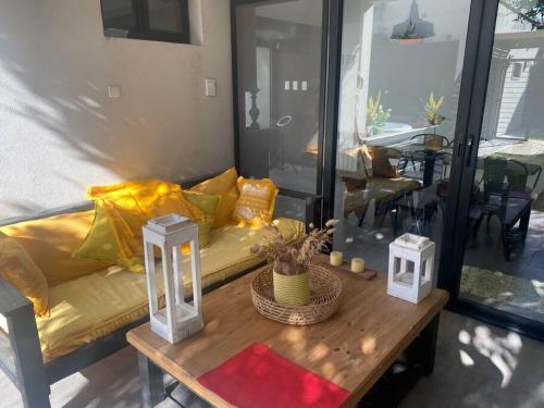 Acogedora casa en Santo Tome في سانتو تومي: غرفة معيشة مع أريكة صفراء وطاولة قهوة
