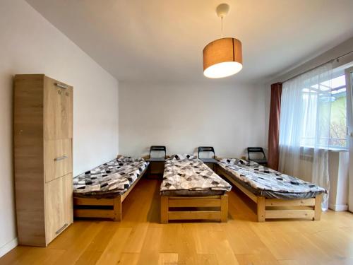 una stanza con quattro tavoli e posti letto di Hostel szopena lotnisko a Varsavia