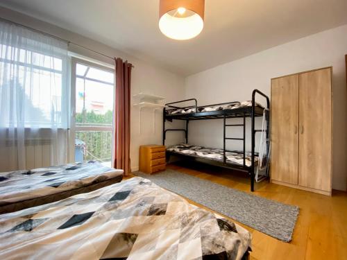 a bedroom with two bunk beds and a window at Hostel szopena lotnisko in Warsaw