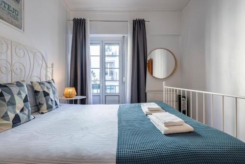 a bedroom with a large bed with towels on it at Mouraria Doll's House in Lisbon