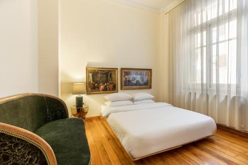 um quarto com uma cama branca e um sofá verde em #Magnolia Apt by halu! Apartments em Tessalônica