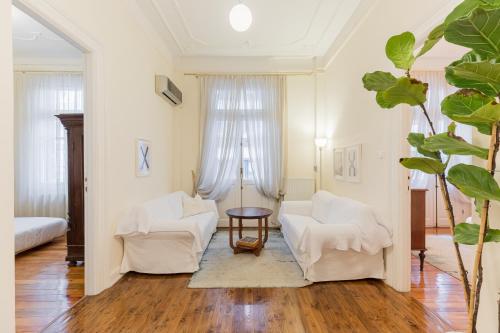 - un salon avec deux chaises blanches et une table dans l'établissement #Magnolia Apt by halu! Apartments, à Thessalonique