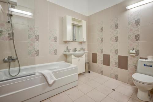 ein Badezimmer mit einer Badewanne, einem WC und einem Waschbecken in der Unterkunft Continental Apartments in Goldstrand