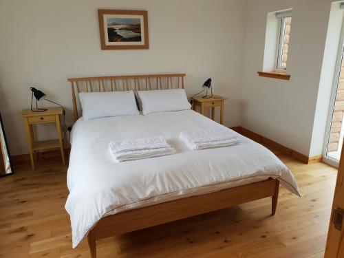 a bedroom with a bed with two towels on it at Bayview 1-Bed Cottage in Isle of Lewis in Bragor