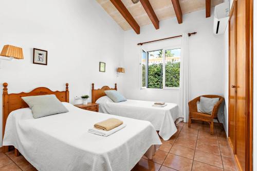 a bedroom with two beds and a window at Villa Miguel Dos in Cala'n Bosch