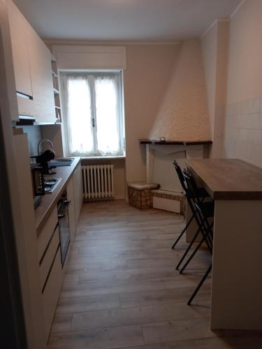 a kitchen with a counter and a table and a window at La casa di Tina - Civenna in Civenna