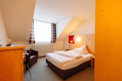 Habitación de hotel con cama y escritorio en Landhotel Gasthof Drexler GbR, en Fürstenfeldbruck