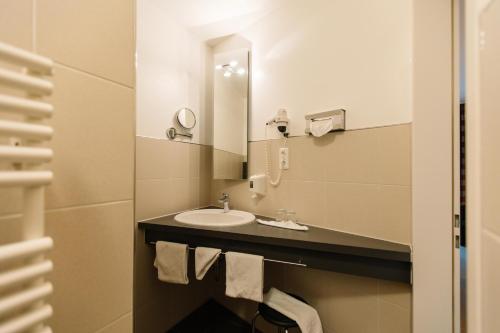 y baño con lavabo y espejo. en Landhotel Gasthof Drexler GbR, en Fürstenfeldbruck