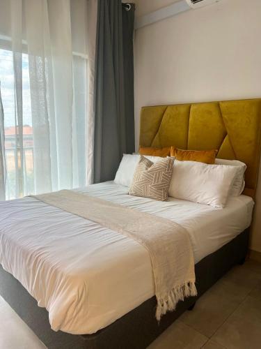a bedroom with a large bed with a large window at White Oasis in Gaborone