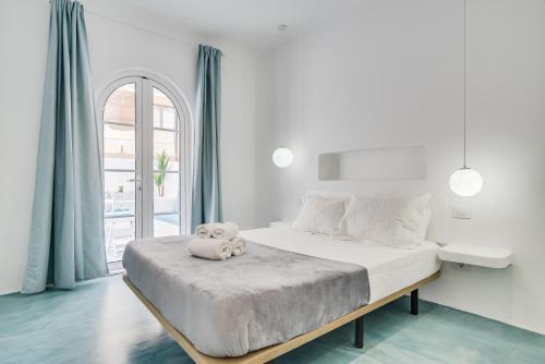 un dormitorio blanco con un osito de peluche sentado en una cama en Home2Book Stylish Oasis Manrique City Center, en Las Palmas de Gran Canaria